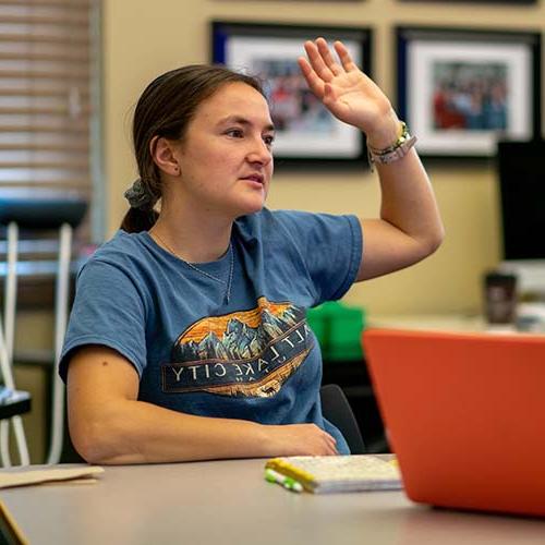 A student raises her hand in class